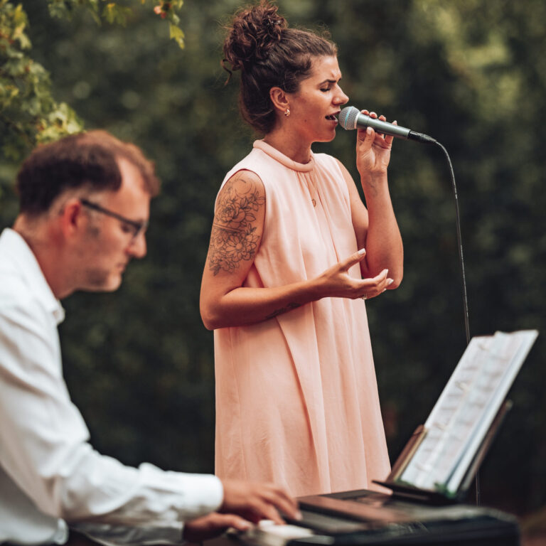 Leonie Jael und Pianist spielen live Musik für Liebespaar, draußen bei freier Trauung